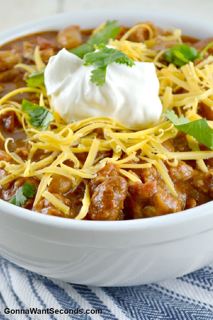 chicken chili topped with shredded cheese and a dollop of sour cream