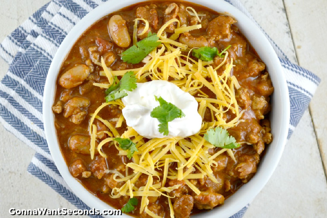 chicken chili topped with shredded cheese and a dollop of sour cream