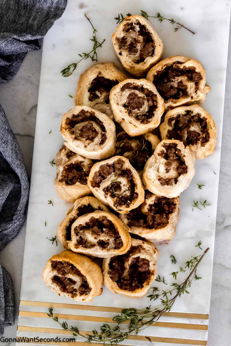 top shot sausage crescent roll pinwheels on a marble serving board