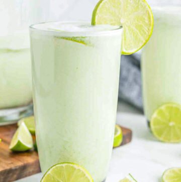A glass of brazilian lemonade garnished with lime wedge on rim