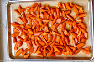 Step 2 how to make honey roasted carrots, Add the carrots to the prepared baking sheet, Pour the honey mixture over the carrots.