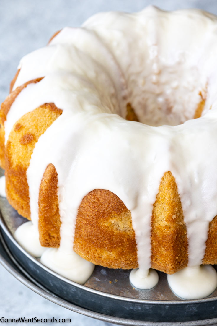 This buttermilk pound cake is very tender, moist, delicate, and has a buttery flavor with a lovely hint of lemon. #buttermilkcake #poundcake buttermilk pound cake with glaze on a cake stand