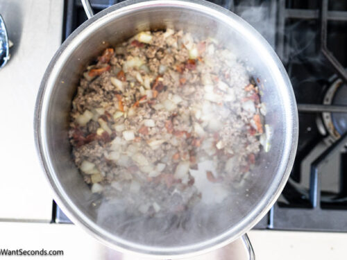 Step 3 how to make cowboy baked beans casserole, Saute the onion and add the garlic. Return the bacon and sausage to the pot.