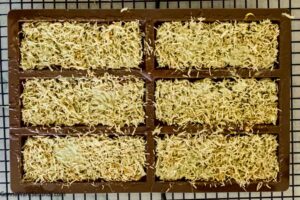Step 3 how to make Dubai pistachio chocolate bar, Remove the chocolate mold from the refrigerator and place a thick layer of the pistachio mixture into each mold.