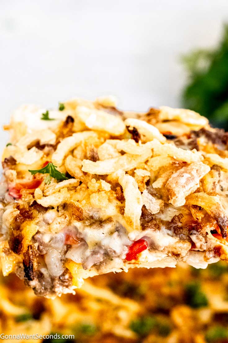 This comforting and hearty hobo casserole uses the layering of potatoes, cheese, spiced meat, and veggies, topped with a creamy savory gravy. #hobocasserole #beefpotatocasserole hobo casserole close up