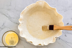 Step 2 how to make fresh peach pie, Place the rolled pie crust to the pie plate and brush the bottom and side with beaten egg. Place in the fridge.