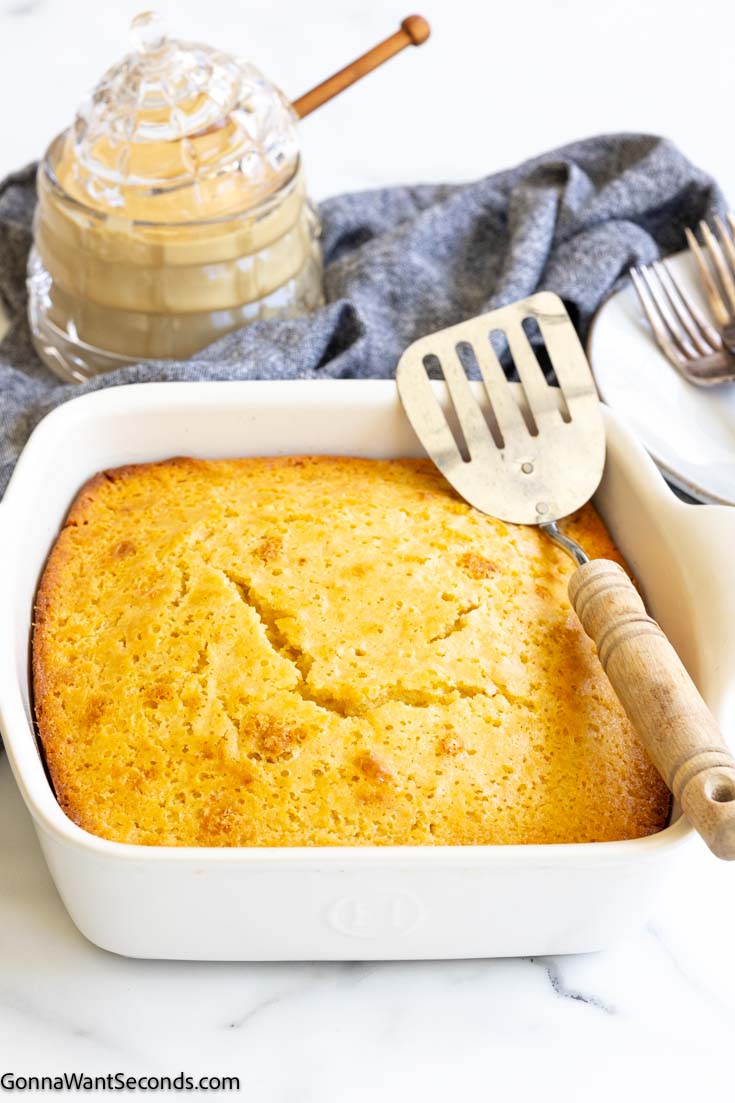 This sweet cornbread is soft, moist, and perfectly cake-like with honey and vanilla. A fluffy from-scratch recipe that pairs beautifully with chili and soup. #cornbread #sidedishes moist sweet cornbread in a baking dish