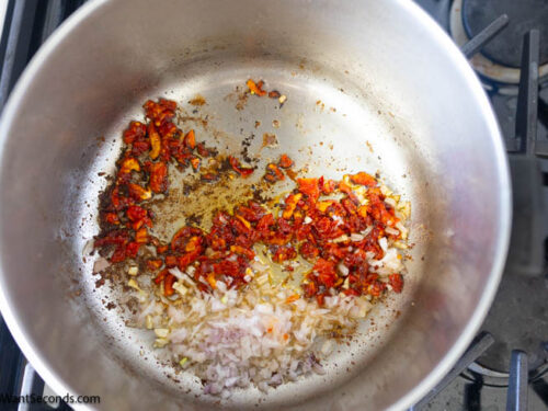 Step 5 how to make marry me chicken with pasta, In the same skillet, saute the shallots, garlic, and sun-dried tomatoes.