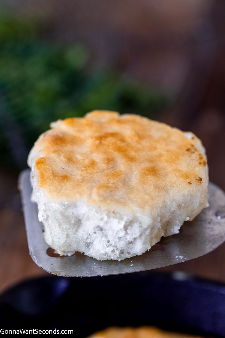 Our 7-up biscuits use the famous soda to create a light, tender, flakey biscuit that is a bit sweet, but not too sweet! You'll love these! #biscuits #7upbiscuits 7 up biscuits with sour cream on a spatula