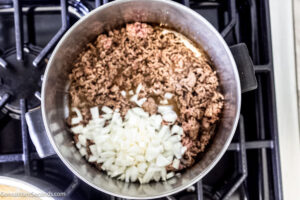 Step 2 how to make old fashioned cowboy spaghetti, Add the onions and garlic to the meat.