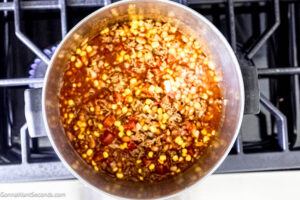 Step 3 how to make cowboy spaghetti with beans, Add the seasonings and spices. Pour the beer, and stir in the undrained Rotel, tomato sauce, chili beans, and corn.