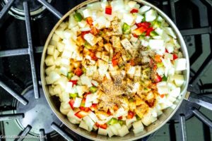 Step 3 how to make smothered potatoes with onions and bell peppers, Add potatoes, onion, bell peppers. Sprinkle with the seasoning mixture. Cook until the veggies are golden brown.