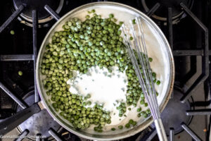 Step 6 how to make creamed green peas, Stir in thawed peas and heavy cream.