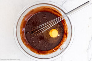 Step 3 how to make chocolate fudge pie, Add eggs to the mixture, one at a time. Whisk.