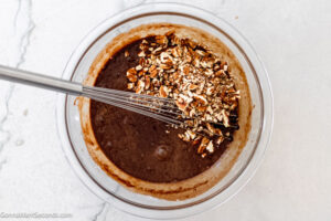 Step 4 how to make old fashioned fudge pie, Add vanilla and salt then whisk. Add pecans and stir.