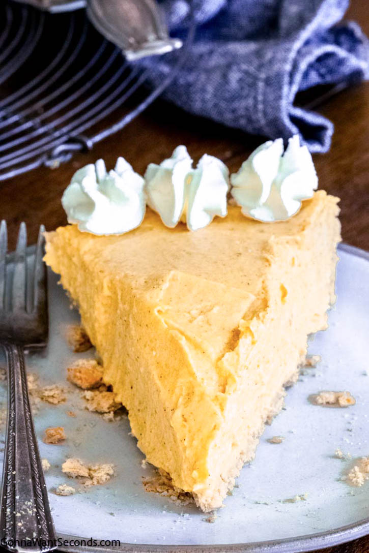 This no bake pumpkin pie takes 15 minutes or less to make and tastes fabulous. No oven, no mess! Using a pre-make graham cracker crust, it's so easy to make. #nobakepie #pumpkinpie a slice of no bake pumpkin pie with cream cheese