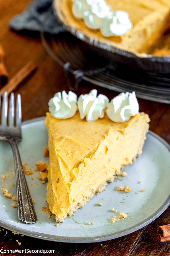 This no bake pumpkin pie takes 15 minutes or less to make and tastes fabulous. No oven, no mess! Using a pre-make graham cracker crust, it's so easy to make. #nobakepie #pumpkinpie a slice of no bake pumpkin pie with cream cheese
