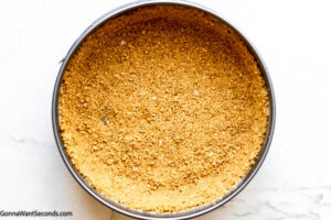 Step 4 how to make pumpkin pie cheesecake, Transfer crumb mixture to prepared springform pan and press crumbs on the bottom and up the sides. Bake.