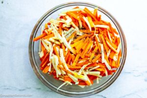 Step 2 how to make roasted carrots and parsnips with rosemary, Toss with salt, pepper, and vegetable oil until evenly coated.