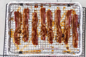 Step 5 how to make million dollar bacon, Dip bacon slices in sugar mixture, coating evenly on both sides. Return to the oven and bake.