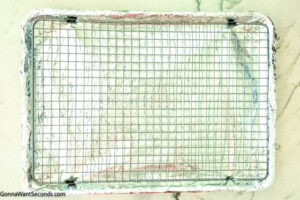 Step 1 how to make million dollar bacon, Line a rimmed baking sheet with aluminum foil. Set a wire baking rack inside baking sheet.