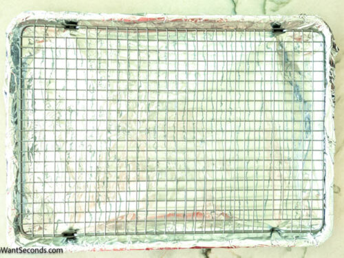 Step 1 how to make million dollar bacon, Line a rimmed baking sheet with aluminum foil. Set a wire baking rack inside baking sheet.