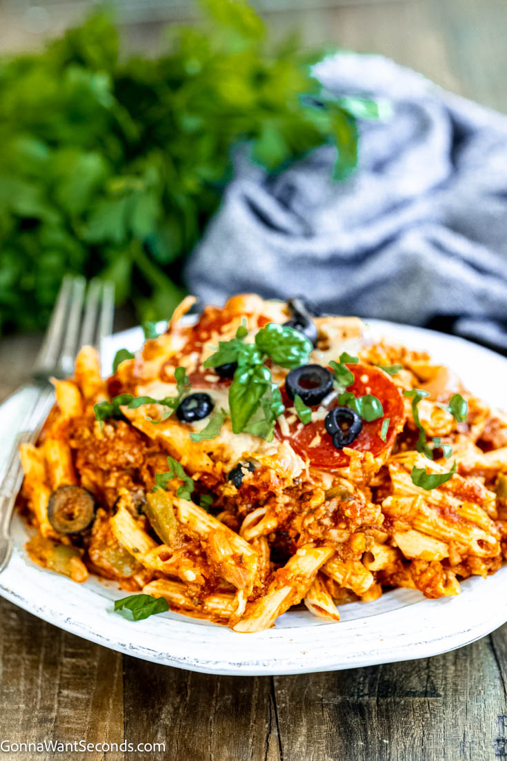 Our deliciously hearty pizza casserole will be kids of all ages will race to the dinner table when this is on the menu! Ooey-gooey, cheese YUM! #pizzacasserole #pizzapastacasserole pizza casserole on a plate