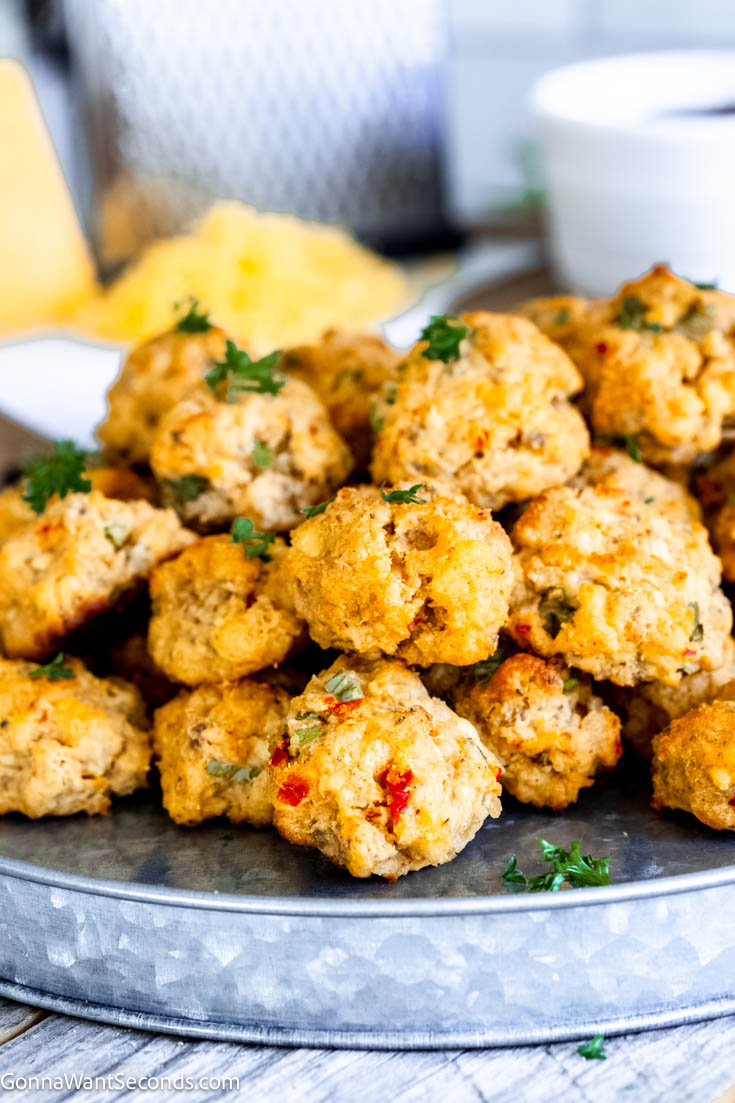 These moist and savory pimento cheese sausage balls are one of my favorites because these little appetizers are crispy on the outside and moist on the inside. #sausageballs #pimentocheese a pile of Pimento Cheese Sausage Balls