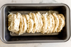 Step 4 how to make Pull Apart Garlic Bread, Stack it vertically, on top of one another. Place the 2 stacks together, horizontally, in prepared loaf pan so they reach end to end in pan.