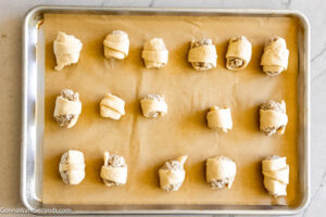 Step 6 how to make Sausage Cream Cheese Crescents, Place a dollop of the sausage mixture at the wide end of the triangles. Roll up the crescents.