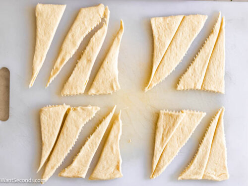Step 5 how to make Sausage Cream Cheese Crescents, Cut each one in half vertically from the tip.