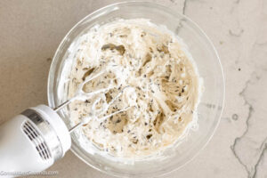 Step 2 how to make Booty dip dessert, Using a hand-held electric mixer, beat together until evenly combined. Add Cool Whip and mini chocolate chips and gently fold with a large rubber spatula.