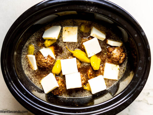 Step 8 how to make Mississippi pot roast meatballs, Arrange butter slices and pepperoncini peppers over meatballs. Cover and cook on low.