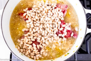 Step 5 how to make pinto bean soup, Add drained beans, Cajun seasoning, and bay leaves.