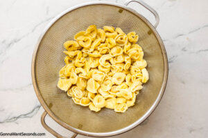 Step 1 how to make tortellini casserole, Cook the tortellini according to the package instructions.