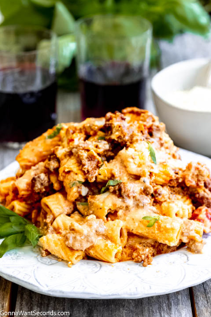 Baked rigatoni is a cheesy casserole with layers of meaty sauce, with ricotta cheese filling, topped with mozzarella cheese, parmesan, and rigatoni pasta. #rigatoni #bakedrigatoni baked rigatoni on a plate