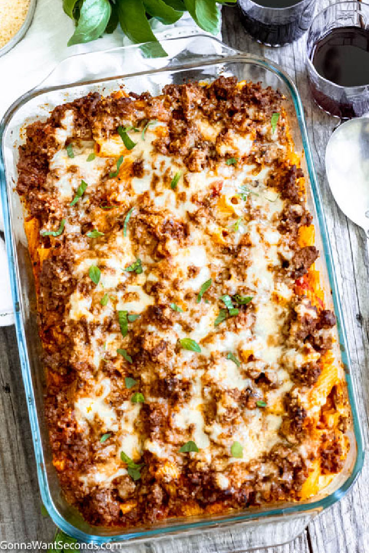 Baked rigatoni is a cheesy casserole with layers of meaty sauce, with ricotta cheese filling, topped with mozzarella cheese, parmesan, and rigatoni pasta. #rigatoni #bakedrigatoni baked rigatoni with ricotta in a casserole dish
