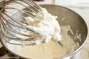 Step 4 how to make Creamy Fruit Salad, In a large bowl, beat the cream, and lemon juice until the mixture is frothy.
