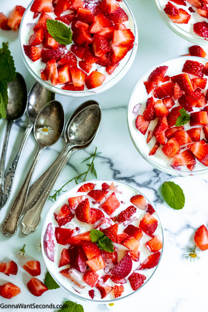 This frescas con crema just may become your new favorite breakfast, snack, or dessert. Sweet, juicy strawberries are bathed in a rich, sweet, and very mildly tangy sauce! #strawberries #frescasconcrema frescas con crema in bowls