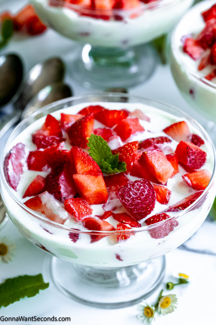 This frescas con crema just may become your new favorite breakfast, snack, or dessert. Sweet, juicy strawberries are bathed in a rich, sweet, and very mildly tangy sauce! #strawberries #frescasconcrema frescas con crema in a dessert bowl