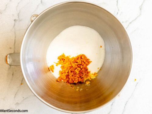 Step 1 how to make orange cake, In the bowl of a stand-up mixer, add sugar and orange zest.