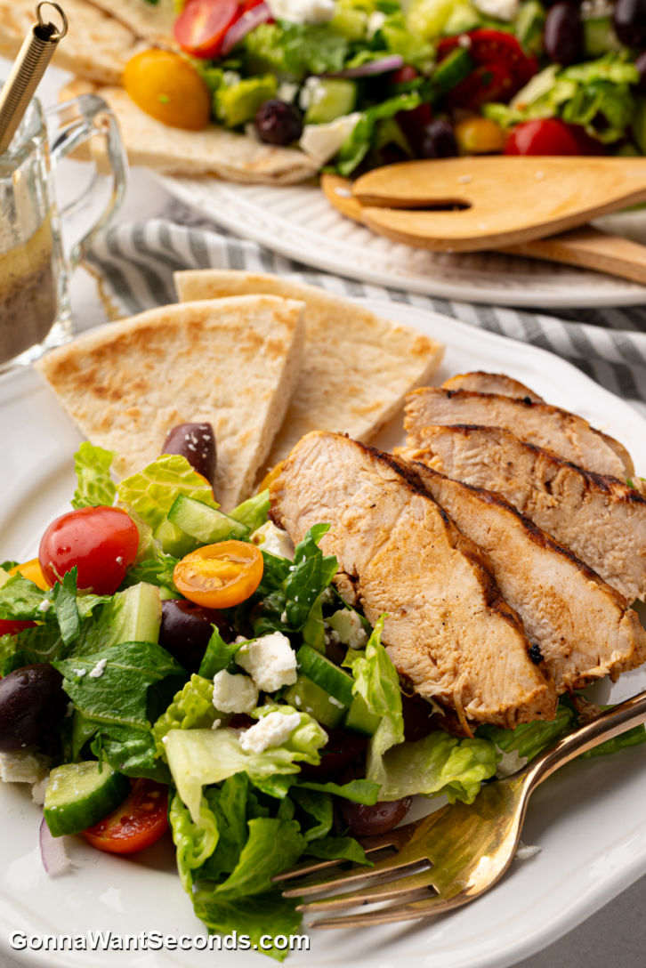 This Grilled Chicken Greek Salad is fresh, flavorful, + easy! Loaded with crisp veggies, juicy marinated chicken, + a zesty homemade dressing. #grilledchicken #greeksalad Grilled Chicken Greek Salad on a plate