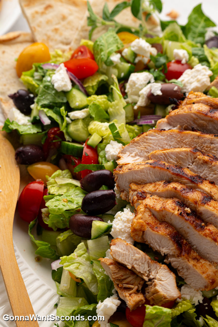 This Grilled Chicken Greek Salad is fresh, flavorful, + easy! Loaded with crisp veggies, juicy marinated chicken, + a zesty homemade dressing. #grilledchicken #greeksalad Grilled Chicken Greek Salad on a plate