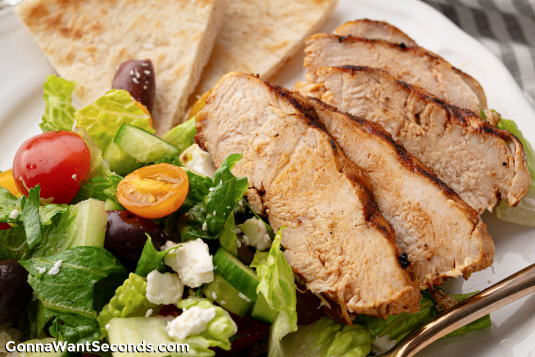 This Grilled Chicken Greek Salad is fresh, flavorful, + easy! Loaded with crisp veggies, juicy marinated chicken, + a zesty homemade dressing. #grilledchicken #greeksalad Grilled Chicken Greek Salad on a plate