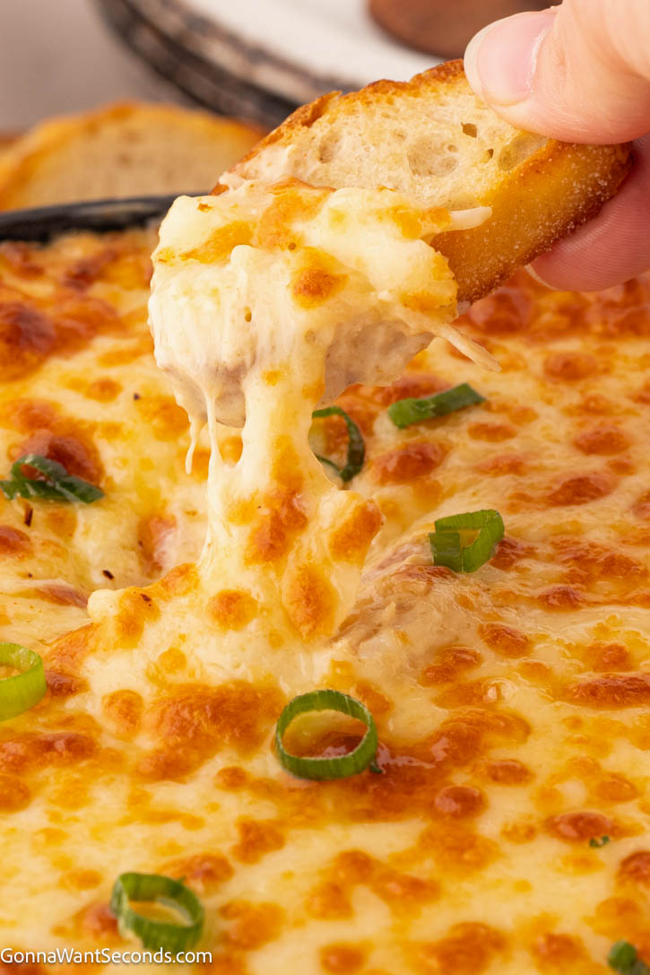This hot crab dip is rich, creamy, and bursting with sweet crab flavor—perfect for weekends with the family, parties, or game day gatherings. #crabdip #hotcrabdip melting hot crab dip dripping off a crostini