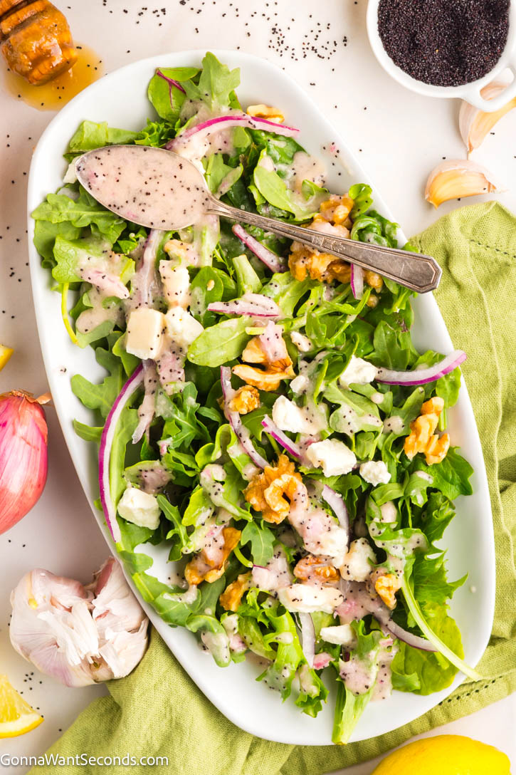 Our homemade poppy seed dressing will make any salad you make so delicious! It's the perfect balance between sweet and tangy. You can whip this up in a minute! #saladdressing #poppyseed Poppy seed dressing drizzled over a salad