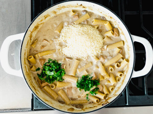Step 9 how to make Rigatoni D, Add parmesan, basil, parsley, and cooked mushrooms. Simmer until the sauce thickens a bit.
