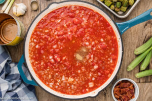 Step 5 how to make Stewed Okra and Tomatoes, Add the canned plum tomatoes, tomato paste, and chicken broth. Stir in the seasonings and the hot sauce, then simmer until the tomatoes have reduced some.