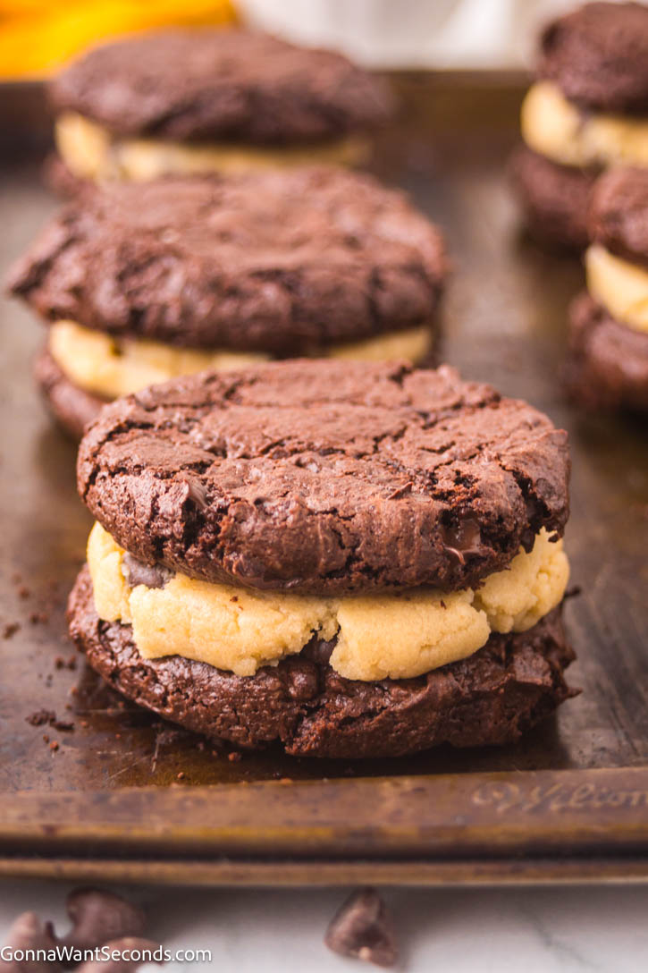 Indulge in brownie cookies with cookie dough filling. This fun dessert is rich, fudgy, and utterly irresistible for all ages. #browniecookies #cookiedough Brownie Cookies with Cookie Dough Filling on a sheet pan