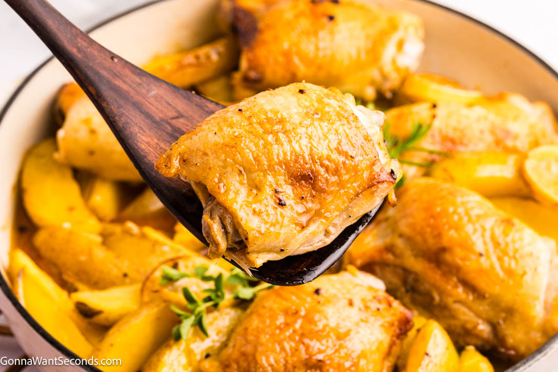 This Greek Lemon Chicken and Potatoes is a one-pan wonder—juicy chicken, tender potatoes, and bright lemon make an easy, cozy family dinner. #greekchicken #chickenandpotatoes spoon drizzling sauce over Greek Lemon Chicken with Potatoes